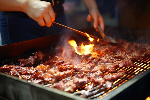 La carne asada a mano humana en la parrilla de la barbacoa