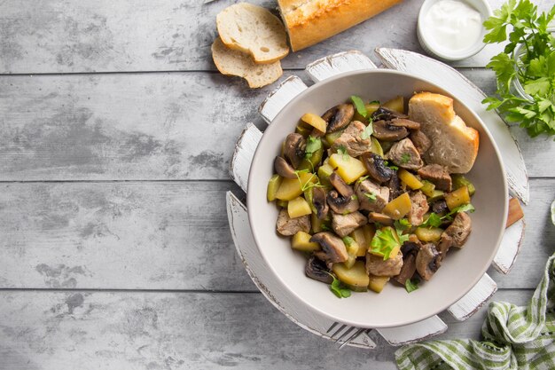 Foto carne asada con papas, calabacín y champiñones.