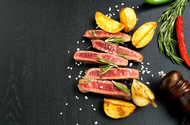 Carne asada a la parrilla. sobre fondo negro.