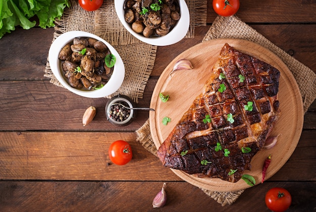 Carne assada com especiarias e alho na mesa de madeira. Vista do topo