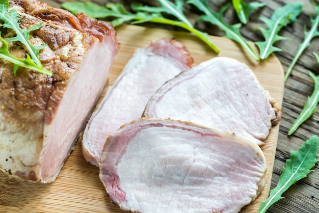 Carne assada com rúcula fresca na placa de madeira