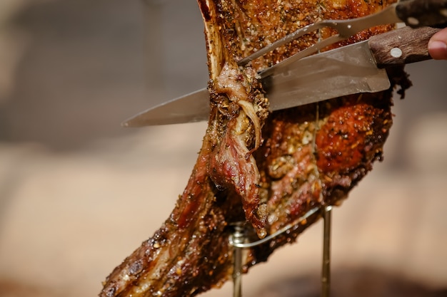 Carne assada e cortada na mesa e fogueira com lenha gaúcha