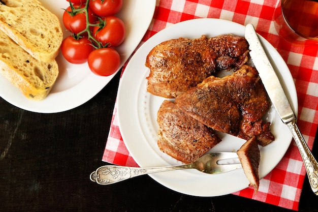 Carne assada e legumes no prato no fundo da mesa de madeira