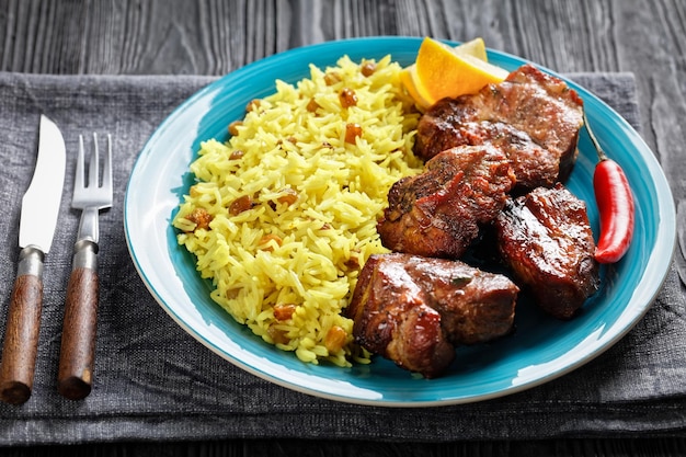 Carne assada servida com arroz de açafrão e passas