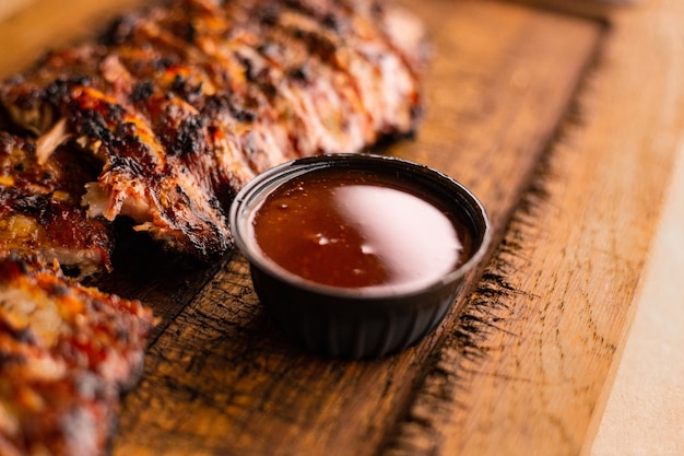 Carne a la barbacoa americana Deliciosas costillas a la barbacoa cortadas en un escritorio de madera Chuletón a la parrilla Carne a la parrilla