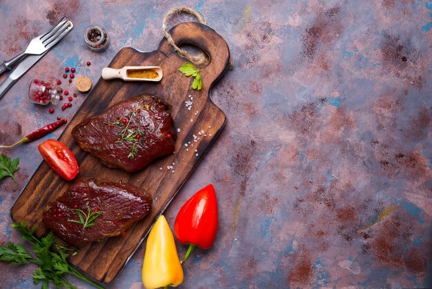 Carne de bistec cruda cruda con especias de pimienta, pimiento búlgaro y tomate