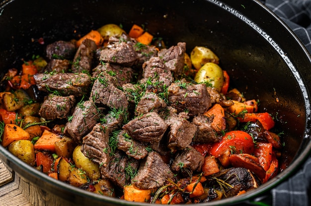 Carne bovina e legumes cozidos em assadeira preta