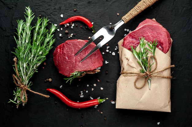 carne de una carnicería, dos filetes con ingredientes. dos trozos de carne sobre hormigón negro