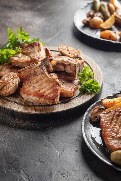 Foto carne de cerdo asada a la parrilla servida con verduras en el fondo de la mesa marrón mesa de fiesta vertical