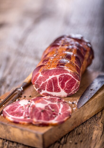 Carne de cerdo Chuleta de cerdo ahumada. Carne ahumada tradicional sobre mesa de madera de roble en otras posiciones.