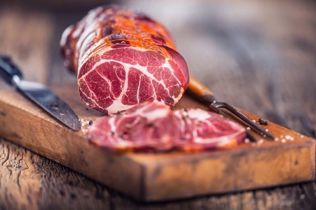 Carne de cerdo Chuleta de cerdo ahumada. Carne ahumada tradicional sobre mesa de madera de roble en otras posiciones.