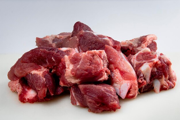 Foto carne de cerdo y costillas de cerdo en tabla de cortar sobre un fondo blanco con recortes