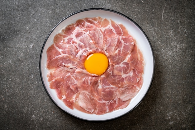 carne de cerdo cruda fresca en rodajas con huevo