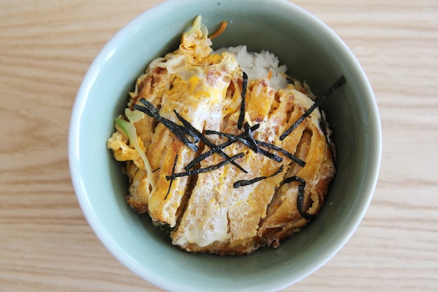 Carne de cerdo frita japonesa con huevo sobre arroz, Katsudon sobre fondo de madera