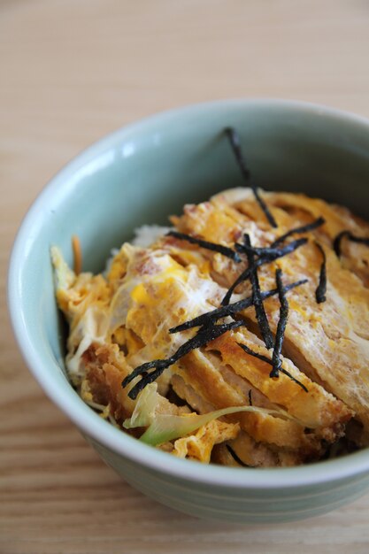 Carne de cerdo frita japonesa con huevo sobre arroz, Katsudon sobre fondo de madera