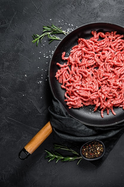 Carne de cerdo picada cruda en una sartén. Vista superior.