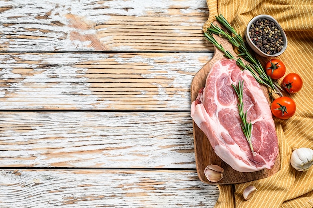 Carne de chuleta de cerdo cruda con hojas de hierbas y especias. Vista superior. Copia espacio