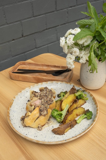 Carne cocida en masa con patatas y brócoli en una mesa de madera