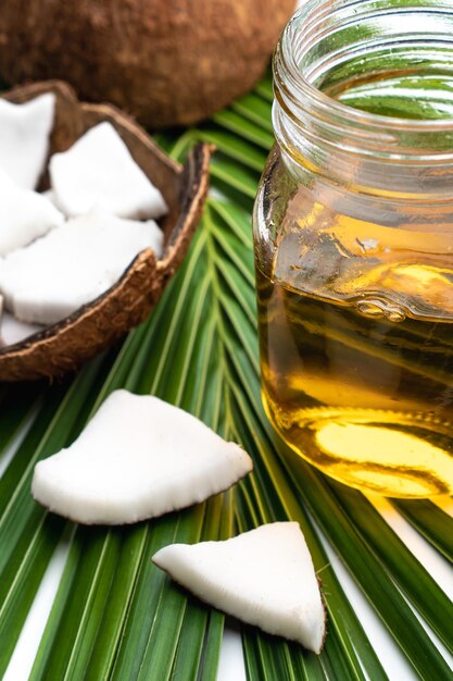 Carne de coco y aceite de coco en botella de vidrio en hoja de coco