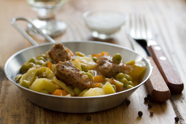 Carne com cenoura, ervilha e batata e vinho