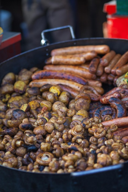 Foto la carne de comida callejera a la parrilla con verduras en una sartén grande son champiñones patatas pimientos