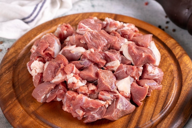 Carne de cordero en cubos Carne roja picada en un plato de madera sobre un fondo de piedra Productos de carnicería de cerca