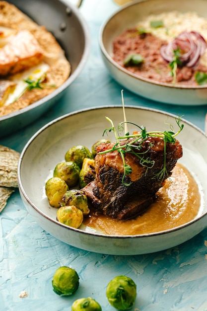 Carne de cordero con hueso en salsa y coles de Bruselas