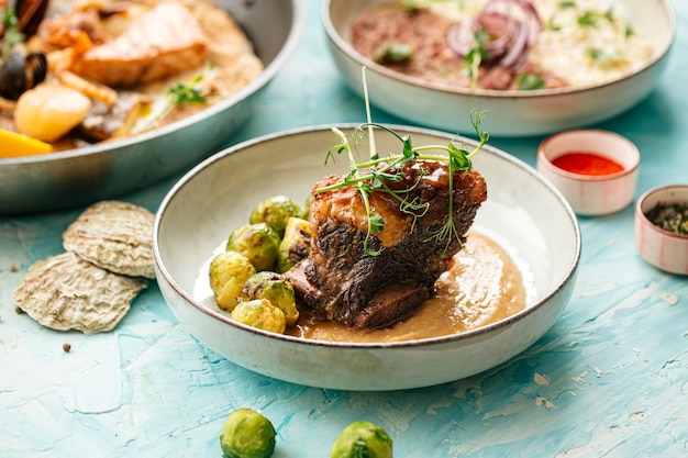 Carne de cordero con hueso en salsa y coles de Bruselas