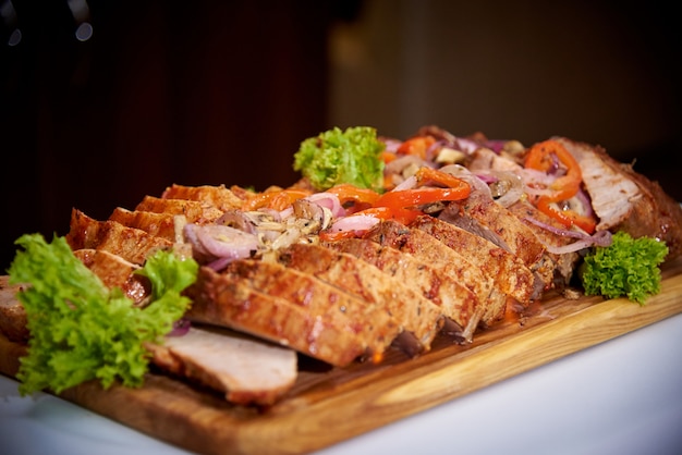 Carne cozida cortada com molho em uma placa de madeira.