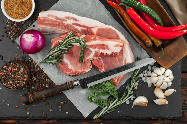 Carne crua com especiarias em uma composição com acessórios de cozinha