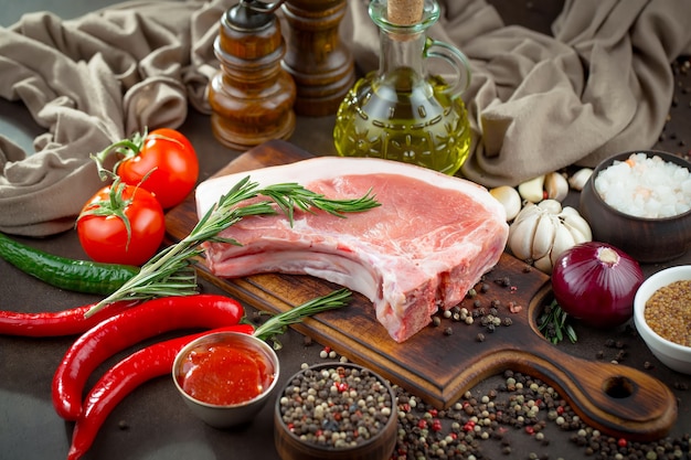 Carne crua com especiarias em uma composição com acessórios de cozinha