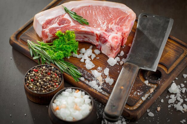 Carne crua com especiarias em uma composição com acessórios de cozinha