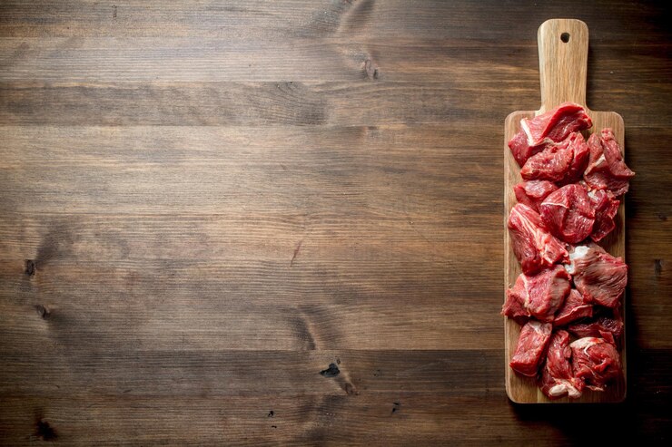 Carne crua cortada em uma placa de corte