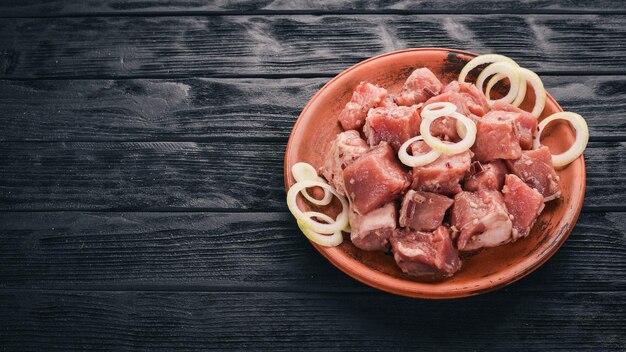 Carne crua crua cortada em cubos na vista superior de fundo rústico de madeira