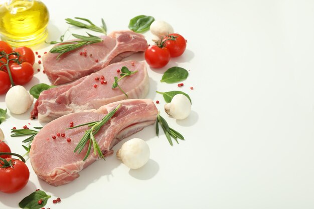 Carne crua e ingredientes para cozinhar no fundo branco