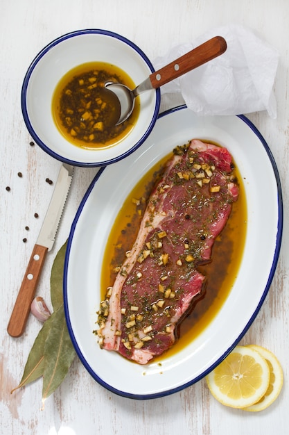 Carne crua em molho no prato e molho na tigela