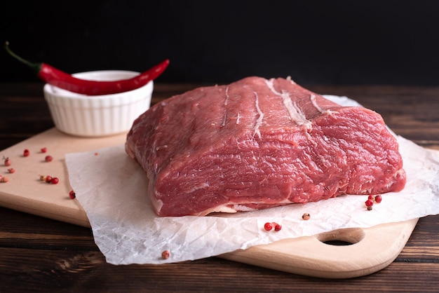 Carne crua em uma tábua de corte, um grande pedaço de filé de vitela