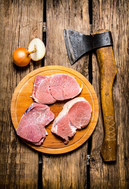 Carne crua fresca com especiarias e machado de corte.