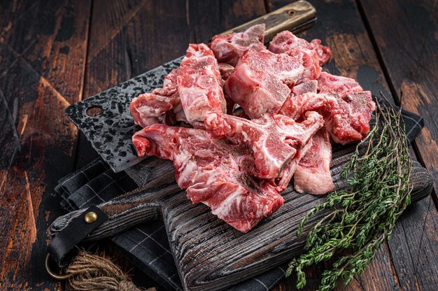 Foto carne crua não cozida cortada em cubos para ensopado em uma tábua de açougueiro. mesa de madeira escura. vista do topo.