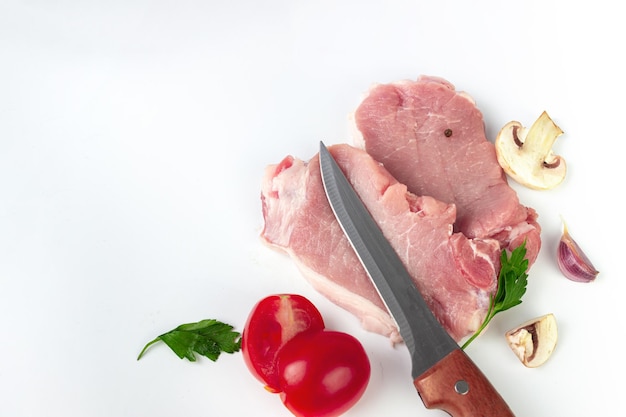 Carne crua pedaços de bifes de carne crua com champignon de pimenta de tomate de alho sobre fundo branco