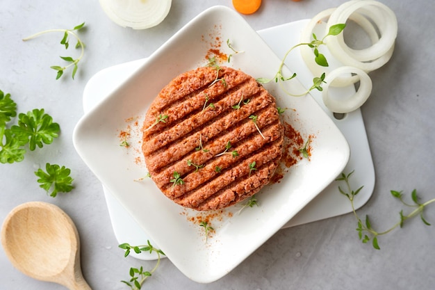 Carne cruda a base de plantas en una tabla de cortar con verduras, alimentos saludables y ecológicos