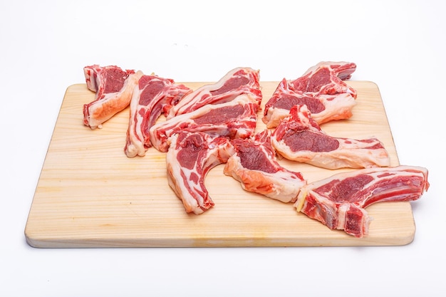 carne cruda carne de res en el hueso sobre una tabla de cortar de madera sobre un fondo blanco aislado