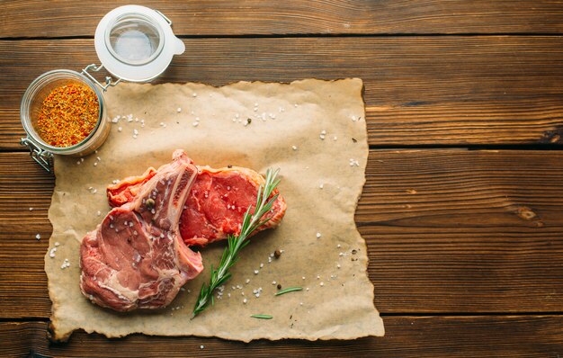 Carne cruda en condimento sobre mesa de madera, vista superior