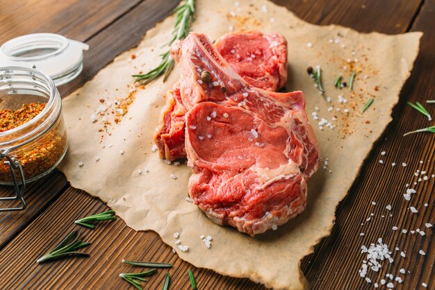 Carne cruda en condimento sobre mesa de madera