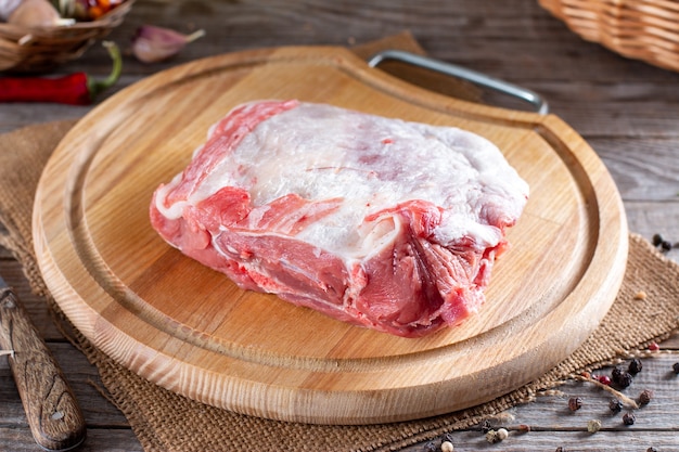 Carne cruda, cordero crudo sobre una tabla para cortar sobre una mesa