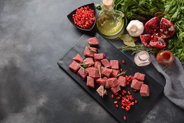 Carne cruda en cubos con ingredientes, hierbas, especias y granada.