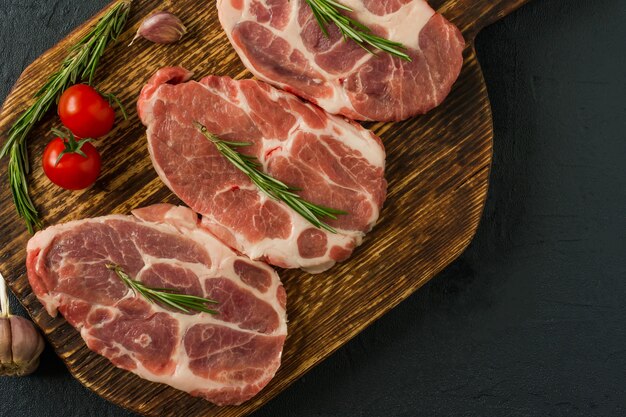 Carne cruda de cuello de cerdo para filetes frescos Picar sobre tabla de cortar de madera. Vista superior.