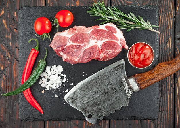 Carne cruda con especias en una composición con accesorios de cocina