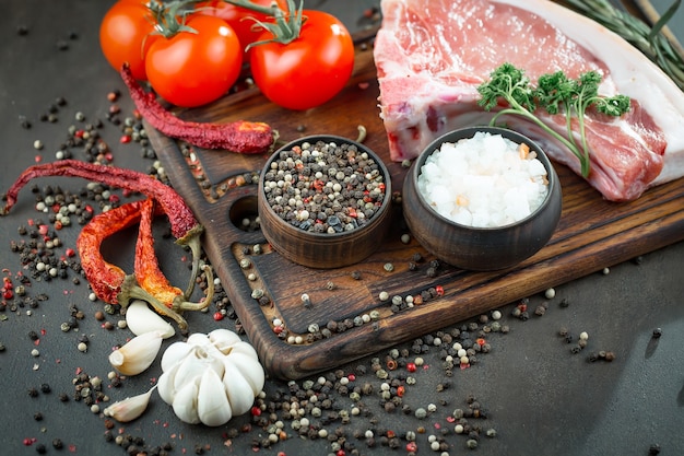 Carne cruda con especias en una composición con accesorios de cocina