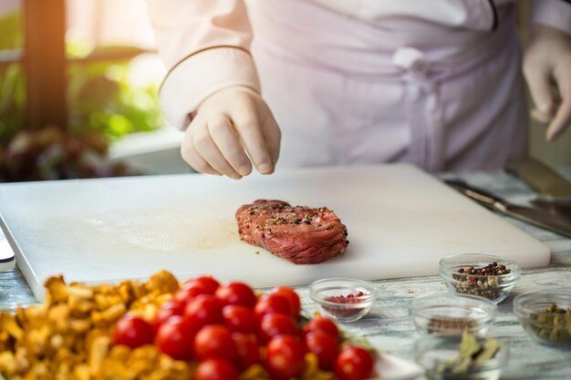 Carne cruda con especias tazones pequeños cerca de la placa de cocción cómo hacer bistec a la pimienta cocinar ternera para el almuerzo